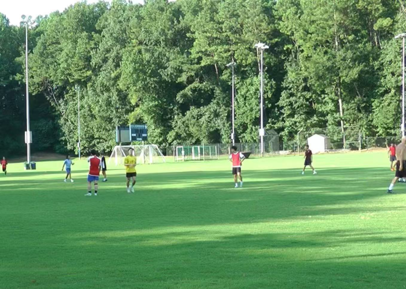 Philip Wang playing football on an Emory field